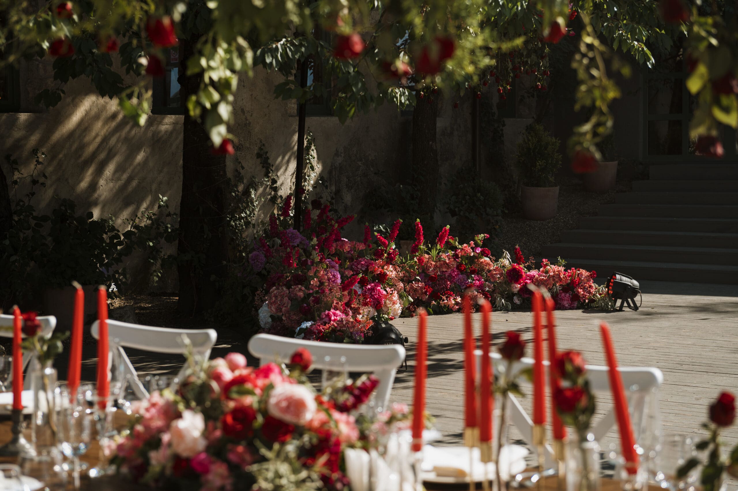 Bold red wedding table with candles and floral arrangements Romantic wedding reception table with red candles and vibrant floral