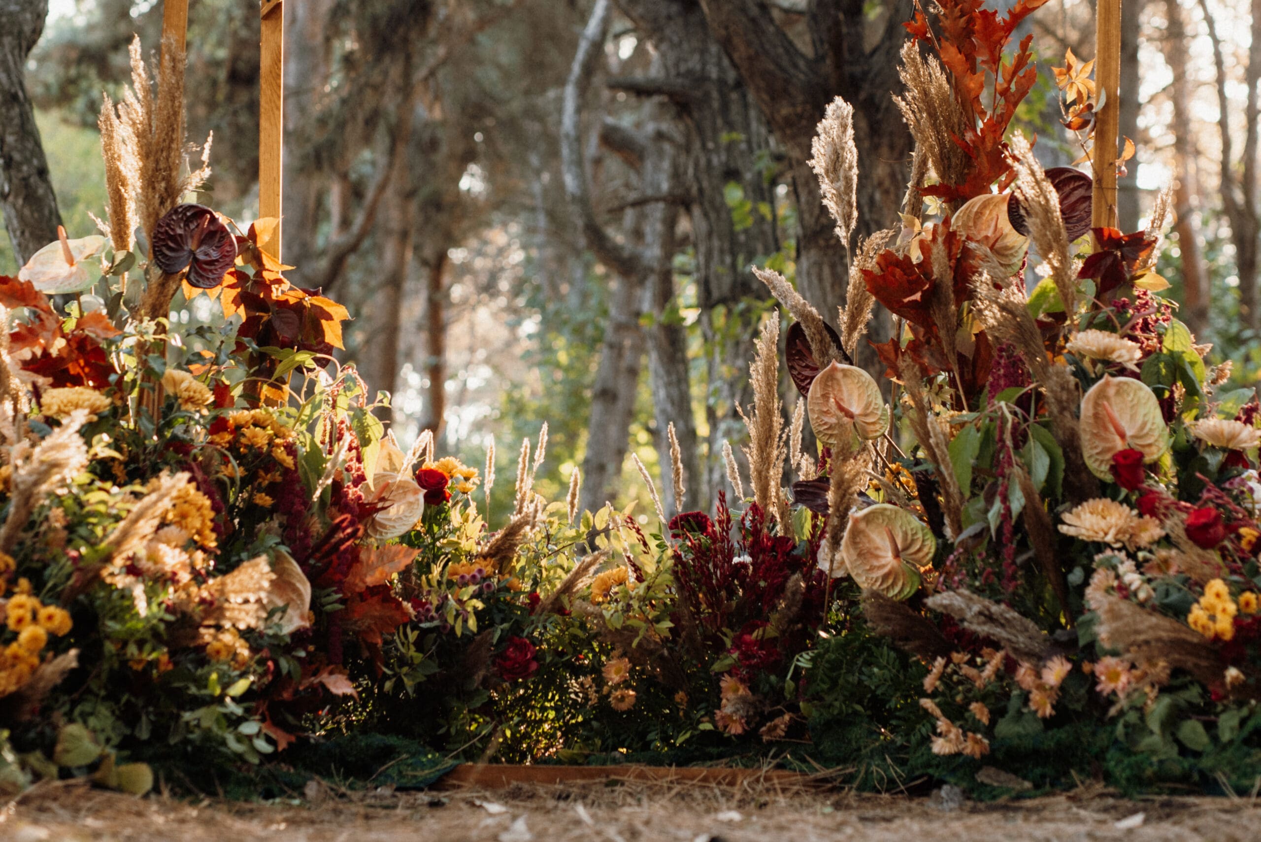 Dried floral wedding ceremony installation Lush wedding ceremony floral installation with dried flowers and grasses in a pine forest setting