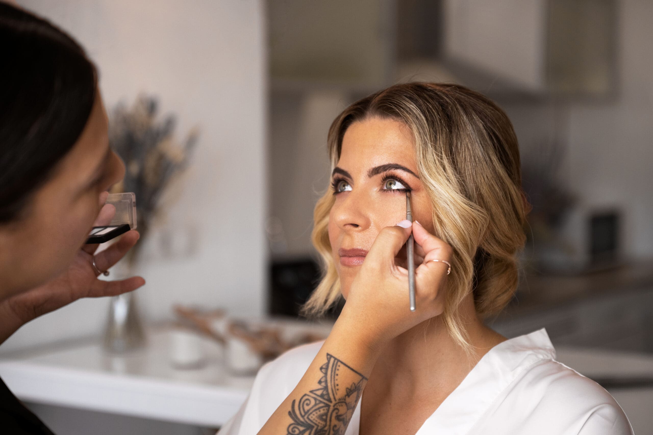 Bride Getting Eye Makeup Applied Before Wedding Bride receiving professional eye makeup application before her wedding ceremony